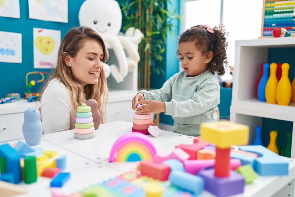 Teacher,And,Toddler,Playing,With,Toys,Sitting,On,Table,At