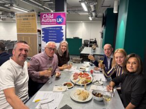 A group of fundraisers enjoy a wine together in a conference room